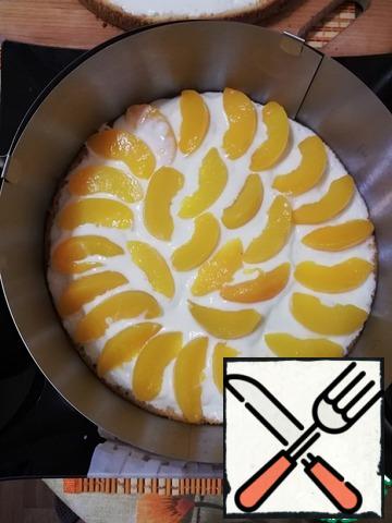 Around the bottom of the cake to install a split ring. On the cake put half the number of peaches.