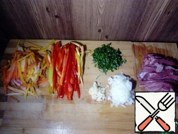 Carrots, bell peppers and meat cut into thin strips ( strips should be approximately the same size). Onions and garlic cut into small cubes. Chop parsley.