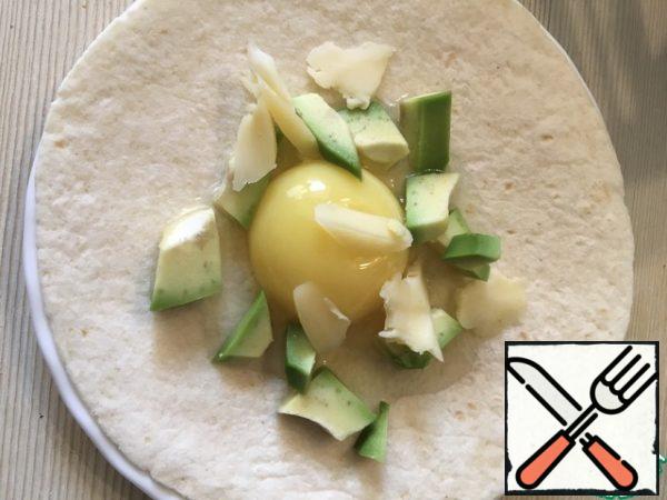Top with avocado, cheese, spices, wrap in a triangle.
