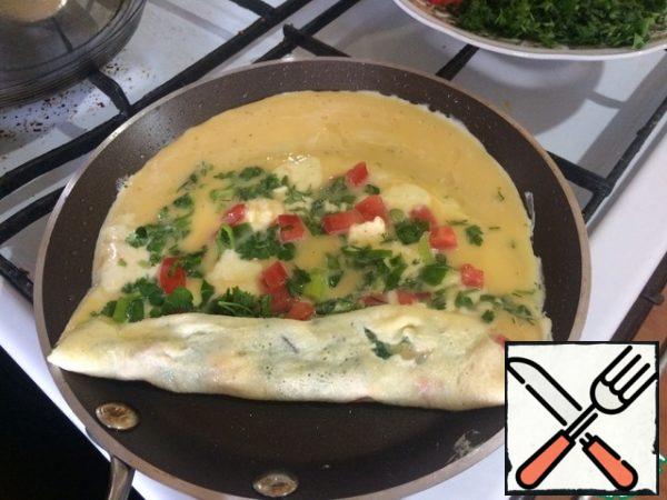 After about a minute, we begin to carefully roll the pancake right in the pan into a roll. If you use two spatulas, it will be much easier. Then, using a spatula, "shift" our roll to the edge of the mold. Pour the egg-milk mixture onto the vacated part of the mold.
