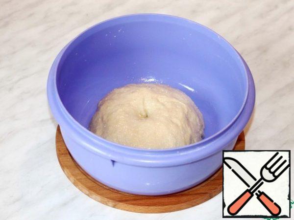 In the liquid mixture in small portions, add the flour mixture and knead the dough. The dough is smooth, plastic and does not stick to the hands. Form a bun from the dough, lubricate with sunflower oil (0.5 tbsp.) and put in a bowl, cover with film. Put the bowl in a warm place to lift the dough 2.5 times.
