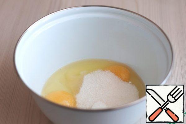 In a bowl, add the eggs (2 PCs.), add baking soda (1 teaspoon) and vanilla sugar (1 teaspoon). Next, add sugar (100 gr.)