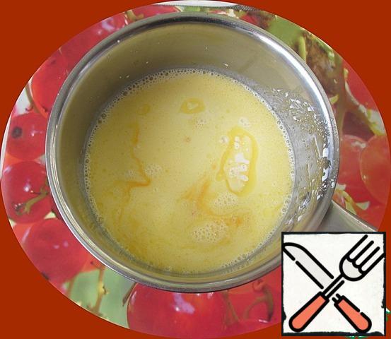 Pour the liquid with oil in a saucepan or bowl, add sugar and add the yolks, mix thoroughly with a whisk or mixer.