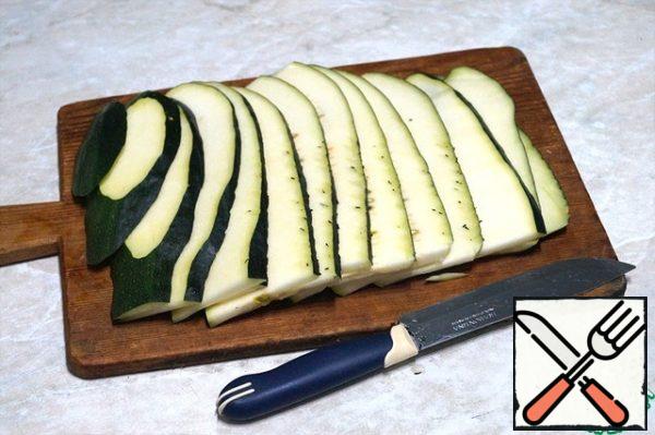 Zucchini cut lengthwise into plates with a thickness of about 5 mm. season with Salt and leave for 5-10 min.