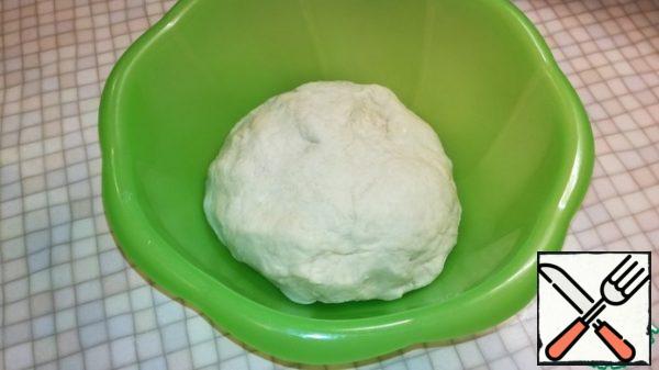Add the remaining flour and knead the dough. Cover with a towel a bowl of dough and put in a warm place for an hour until the volume increases twice.