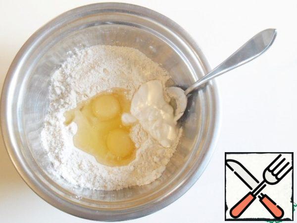 Beat in the eggs, add sour cream.
Start kneading in this funnel, gradually capturing a new amount of flour. First with a fork or spoon, then with your hands.
When the dough begins to gather into a ball.
