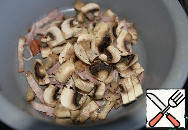 Take a saucepan or pan with a thick bottom, fry the brisket.
Take any mushrooms at will and availability, I have mushrooms. Cut into small pieces, fry together with the brisket.
