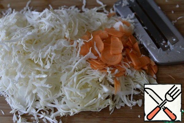Cut the cabbage into thin strips, carrots into thin circles. Grind with salt.