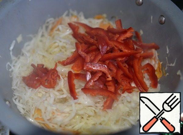 In a frying pan pour oil, fry for 2 minutes on high heat cabbage and carrots.
Red pepper cut into strips, burning-thin rings. Put the peppers to the cabbage, fry everything, simmer on medium heat with the lid open for 10 minutes.