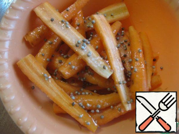 Meanwhile, wash the carrots, peel them if they are thick, cut them in half lengthwise, put them in a bowl, add oil, salt and coriander seeds. Leave aside, stirring occasionally
