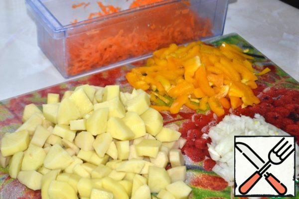 Grate carrots on a coarse grater, cut pepper into small strips, onion into cubes, potatoes into large cubes.
