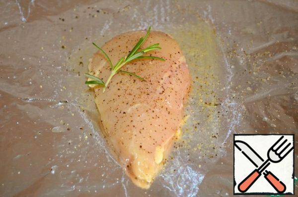 Put the chicken fillet on a double layer of foil, pour orange juice, sprinkle with olive oil, salt and pepper, add a sprig of rosemary, wrap in an envelope. Repeat the same with the second fillet. Cook it in the oven at 220 °C for 35 minutes.
