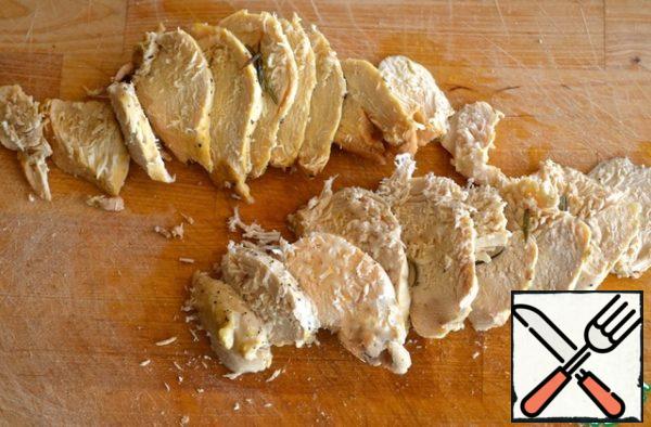 Cut the finished chicken fillet into medium-thick slices. Do not pour out the juice from the foil.
