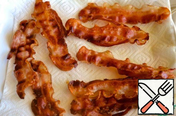 Fry the bacon and dry it on paper napkins.
