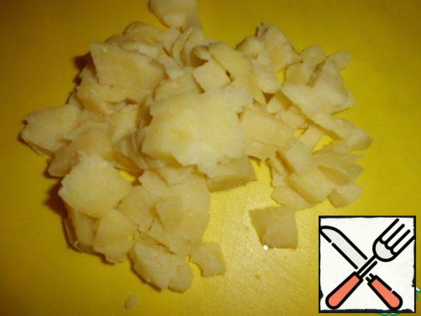 Potatoes are cooled, peeled, cut into cubes.
