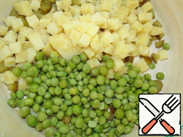 Add the cooled peas to the potatoes with cucumbers.