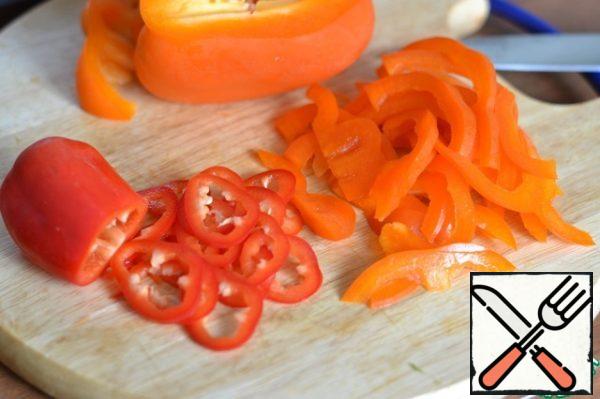 Cut sweet and chili peppers into thin slices.