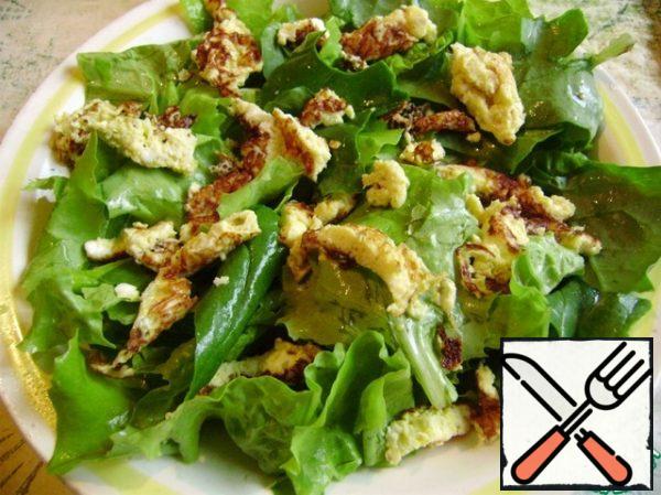 We begin to spread the salad.
Put lettuce leaves and spinach on the bottom of the plate.
Then spread the omelet.
