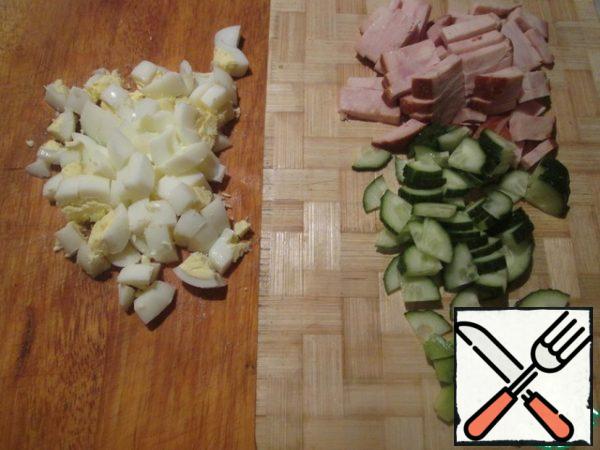 Boil eggs, peel and cut. Cucumber and avocado cut into cubes, ham-straws.