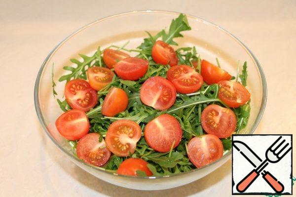 Put the arugula in a large salad bowl, cut the cherry in half and add to the arugula.