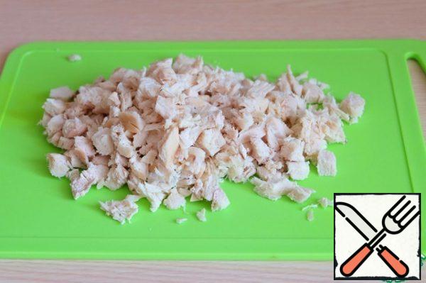 Boil the chicken fillet in salted water, then cut into small cubes.

