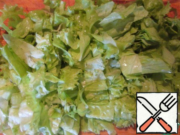 Peel the garlic clove and chop finely. Mix all the dressing ingredients. Wash lettuce leaves, dry, fold in a pile, cut first lengthwise into 3-4 parts, then across, to make small squares.