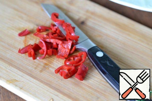 Cut the chilli in half and remove the seeds.
Cut into half rings.