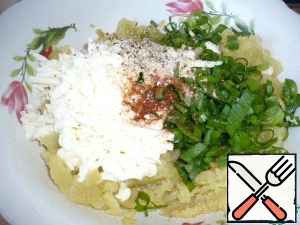 Add grated mozzarella cheese, finely chopped green onions to the mashed potatoes, season with ground black pepper, red paprika, add garlic seasoning and salt to taste. Mix well.
