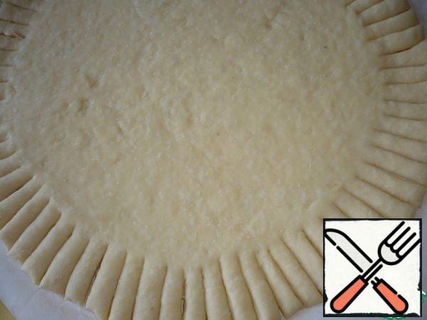 On the rolled out layer of dough, make small incisions along the edge of the circle.
