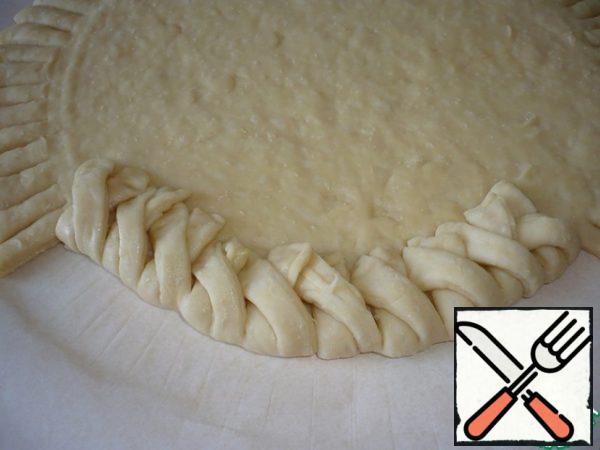 From the cut dough on the edge of the pie to weave a pigtail.