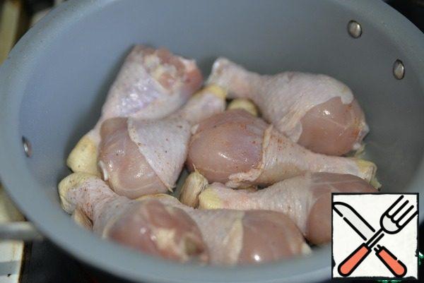 Take the chicken drumsticks (or thighs) wash, dry. RUB with salt and a mixture of peppers and put on a hot frying pan in garlic oil. The oil should be very hot to immediately form a crust on the skin of the chicken.