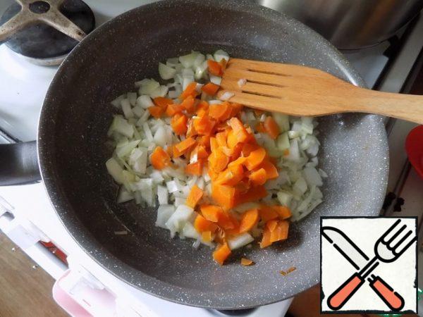 In a frying pan pour the oil, heat it, spread the garlic. Through minute-onion. We gild it and put carrots. Mix everything.