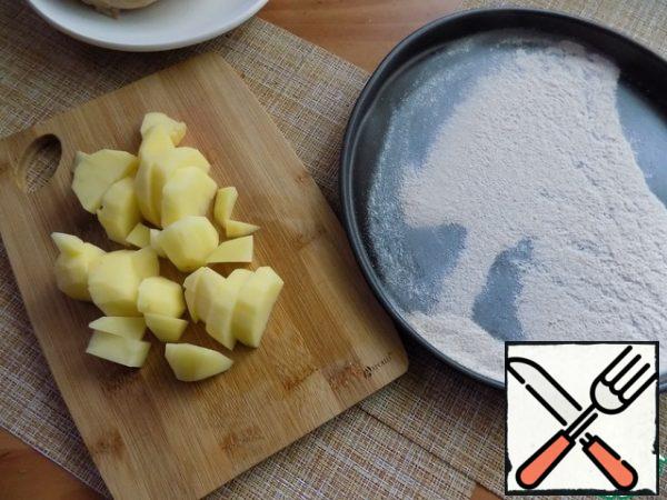 Peel the potatoes, cut it arbitrarily. Send in the pan. We need to dry the flour. I'll do it on a non-stick form in the oven. It's fast, about a minute. It should be distributed evenly in a thin layer on the form. You can dry the flour in a clean dry pan.