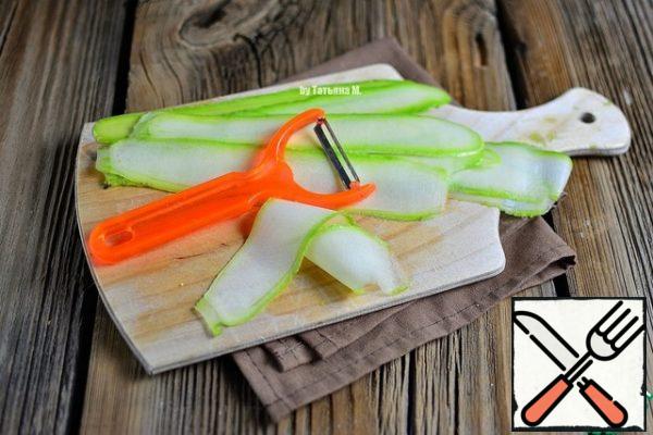 Cut the zucchini into thin slices with a special knife.
