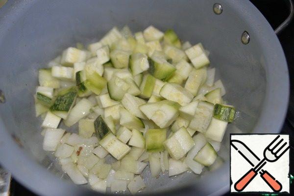 Wash the onions and zucchini, peel and cut into the same cubes as the eggplant. Add the oil to the pan, fry the onion for a couple of minutes, then add the zucchini and fry everything over medium heat for 5 minutes.