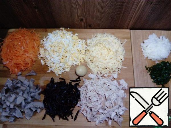 Prepare the products. Boil eggs and chicken breast. Onions and carrots are cleaned. Prunes pour boiling water and leave for-10 minutes. Cut the chicken breast, prunes, mushrooms, green and onions. Eggs, carrots and cheese grate on a coarse grater (one yolk can be left for decoration)