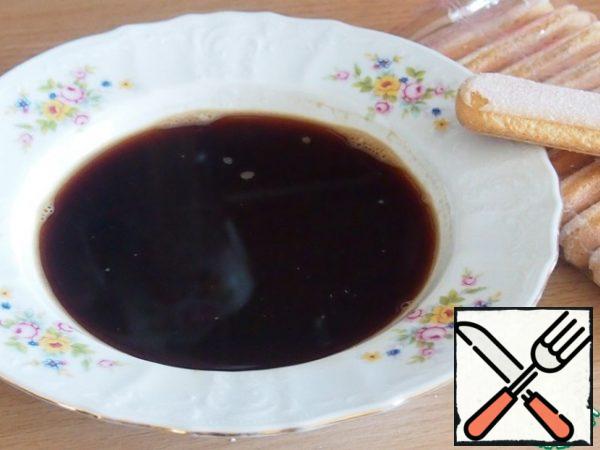 In 150 ml hot water dissolve coffee, add rum or some liqueur, cool. Add alcohol is not necessary, you can add flavor to the coffee. Pour into a wide plate.