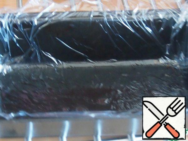 Grease the cake pan with a small amount of vegetable oil and cover with cling film so that its edges protrude above the edges of the mold. The oil is used to ensure that the film sticks to the mold and does not fidget, also later it will help us take the cake out of the mold.
