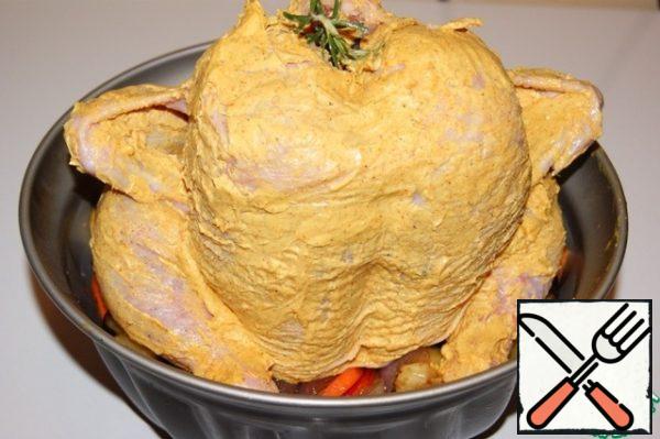 With your hands, gently separate the skin from the chicken in the breast area and lubricate the inside with fragrant oil. Then generously, from all sides, lubricate the whole carcass with fragrant oil, stick rosemary inside through the neck and put a tube on top.
