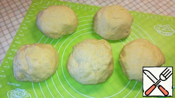 After an hour, knead the dough and divide into five parts, forming balls.
