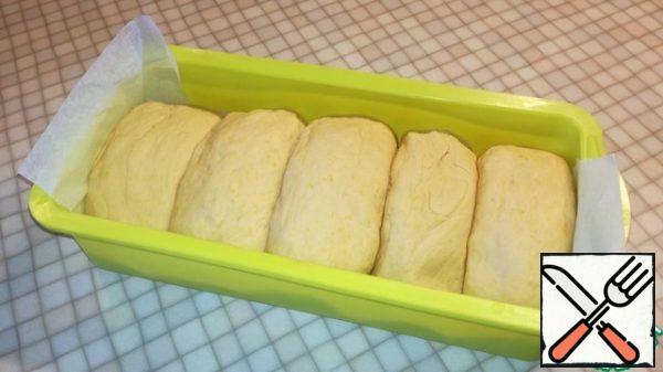 Fold tightly into a silicone mold (size 25x13). The bottom of the mold can be covered with parchment. Cover with a towel and leave for 30 minutes.
