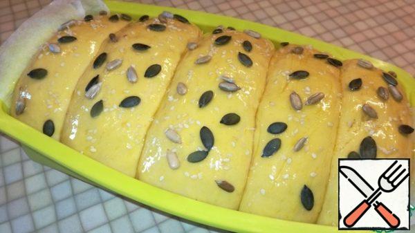 Brush the bread with yolk and sprinkle with seeds.
