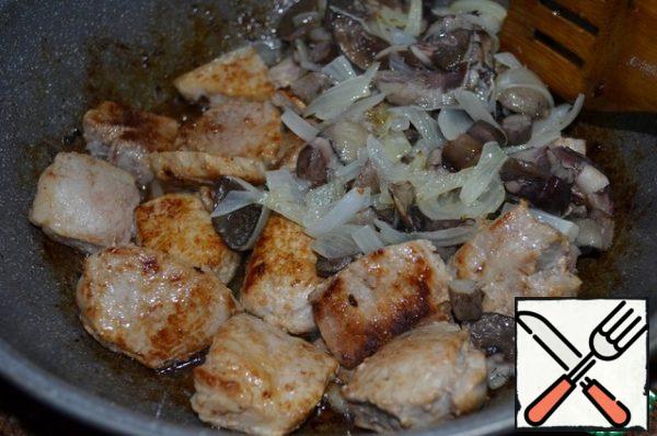 Fry pork in a frying pan, adding 1 tbsp vegetable oil and a straw of smoked bacon, fry until golden brown.
Lay out the mushrooms, fry over medium heat for 5 minutes.
