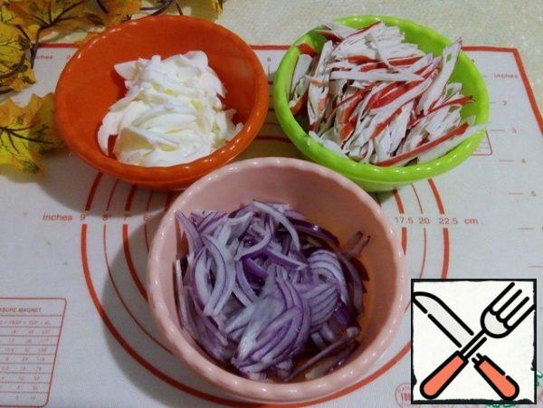 Boiled egg whites cut into strips. Crab sticks in an oblique way - a long straw. Cut the onion into half rings.
