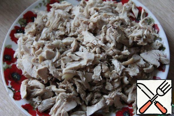 Boiled chicken (it is better to take not only the breast, but also the thighs, so that there is no dry meat) is broken into fibers or finely chopped.
