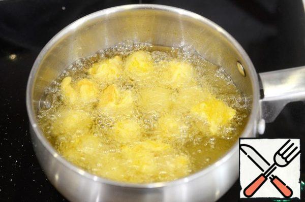 In a saucepan with a thick bottom, heat the oil, form balls or rings from the dough and fry until golden brown. Place on a paper towel to remove excess oil.
