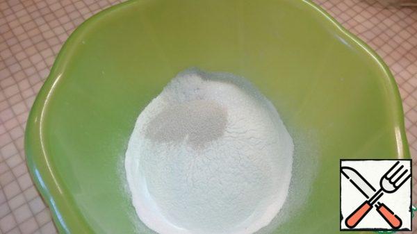 In a bowl sift (200 g) flour, add yeast, salt, sugar. Stir.