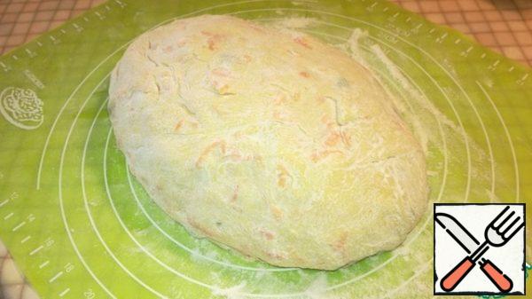 After 30 minutes, knead the dough on a well-floured surface. Form an oval.