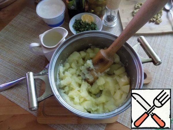 The potato was boiled. Drain the water from it, but keep it. Make a puree, such an average density, as needed, pour the drained liquid. Do not forget that we will still add sour cream. I always use a wooden pusher, it is so ancient.