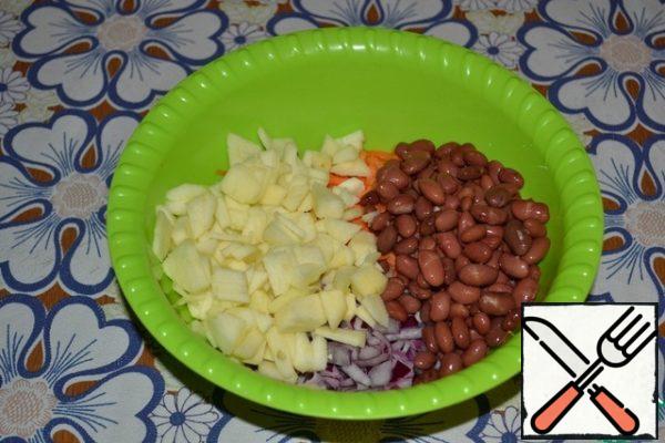 Peel the apples and seeds, cut into small cubes. Add canned beans.
Take apples that are more sour. Sourness gives the salad a special, original taste.
